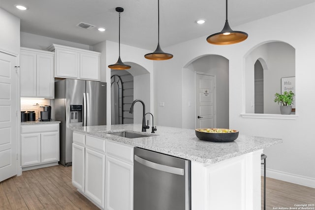 kitchen with light wood finished floors, visible vents, stainless steel appliances, and a sink