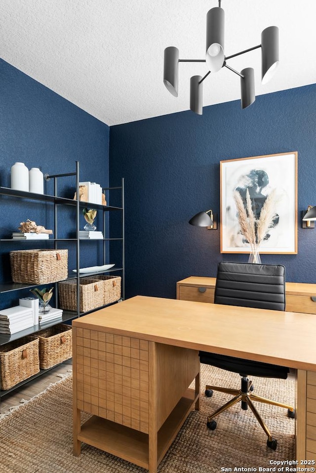 office with a textured ceiling, wood finished floors, and a textured wall