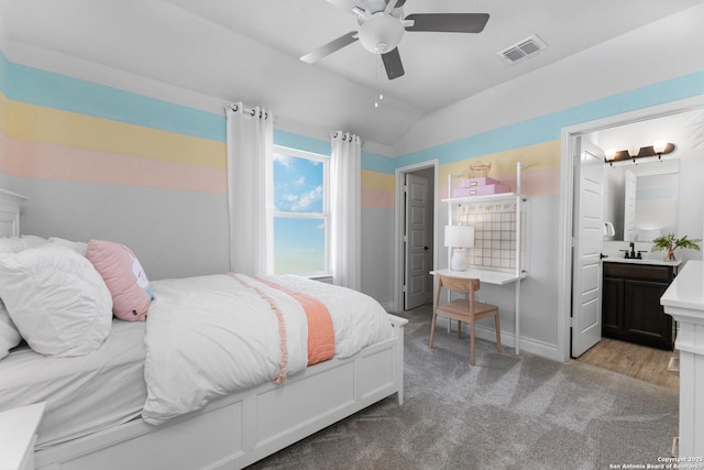 carpeted bedroom featuring lofted ceiling, a sink, a ceiling fan, visible vents, and baseboards