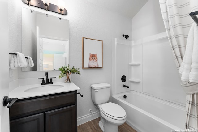 bathroom featuring toilet, wood finished floors, vanity, bathing tub / shower combination, and baseboards