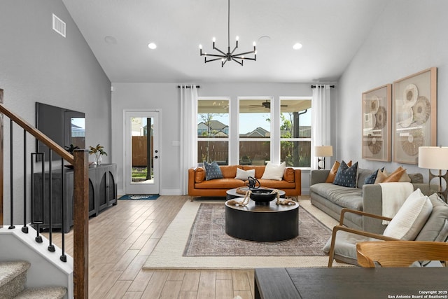 living room featuring recessed lighting, wood finished floors, a notable chandelier, and stairs