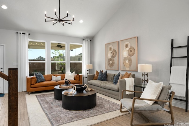 living room with high vaulted ceiling, recessed lighting, wood finished floors, and a notable chandelier