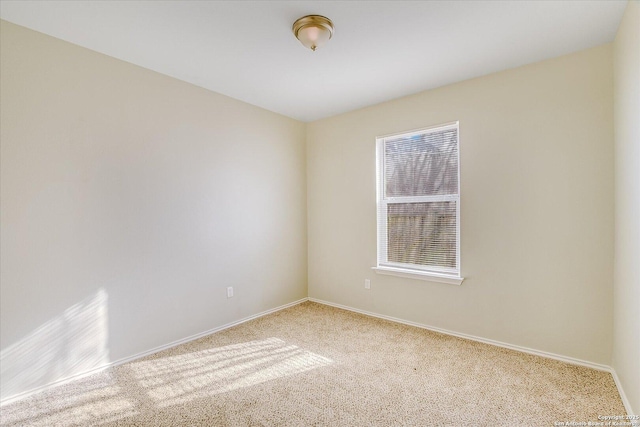 carpeted spare room featuring baseboards