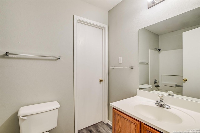 bathroom featuring toilet, wood finished floors, and vanity