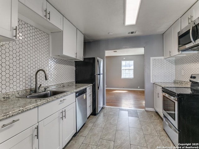 kitchen with visible vents, appliances with stainless steel finishes, white cabinets, and a sink