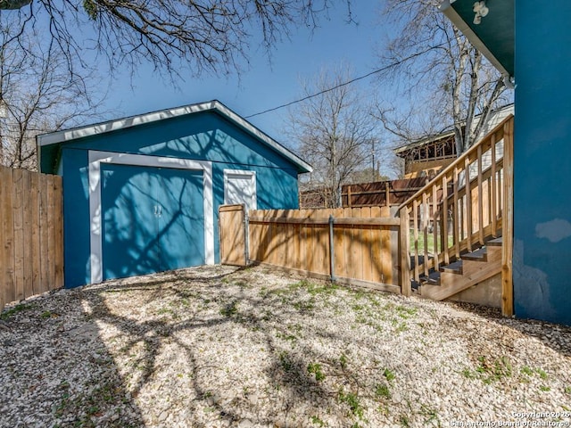 view of yard with an outbuilding, a storage unit, a fenced backyard, and stairs