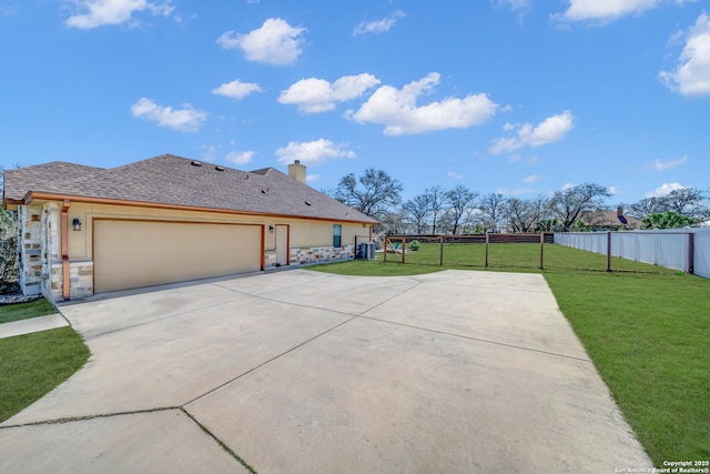 view of front of property with a shingled roof, an attached garage, fence, driveway, and a front lawn