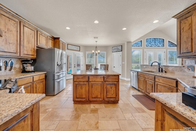 kitchen featuring stone tile floors, brown cabinets, a sink, and french doors