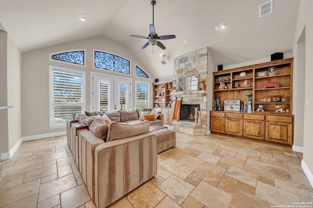 living room featuring a stone fireplace, stone tile floors, visible vents, baseboards, and french doors