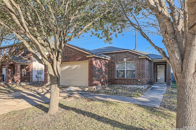 ranch-style home with an attached garage, roof with shingles, concrete driveway, and brick siding