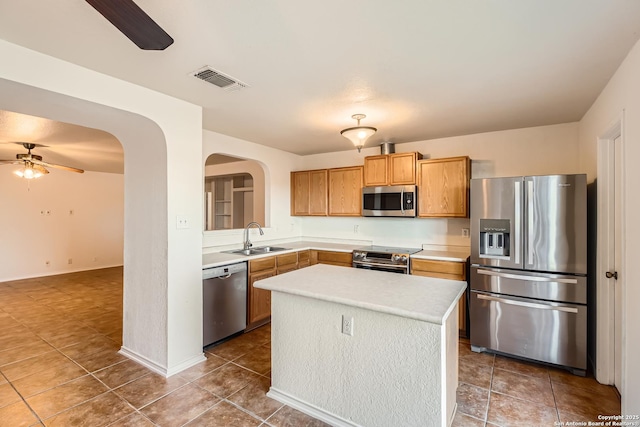 kitchen featuring visible vents, arched walkways, a ceiling fan, stainless steel appliances, and a sink