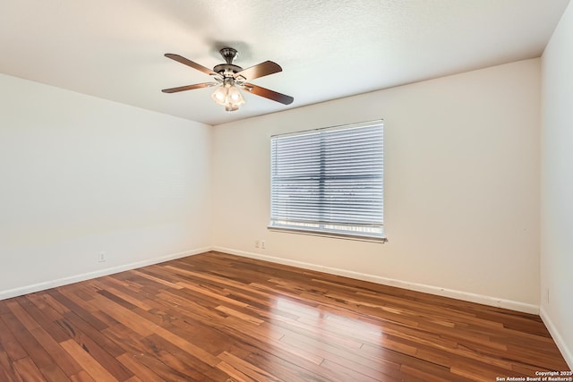 empty room with a ceiling fan, baseboards, and hardwood / wood-style floors