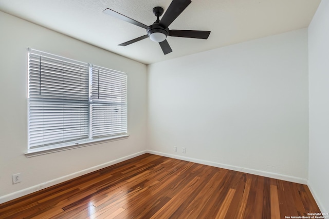 empty room featuring hardwood / wood-style floors, a ceiling fan, and baseboards