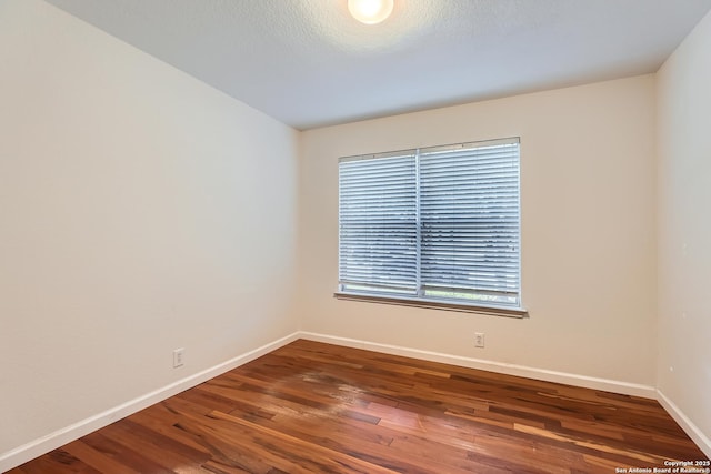 unfurnished room featuring wood finished floors and baseboards