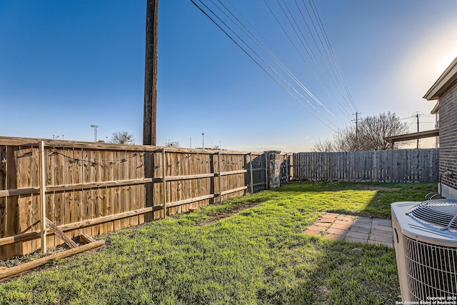 view of yard featuring central air condition unit and a fenced backyard