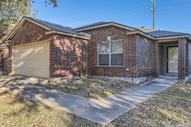 ranch-style home featuring concrete driveway, brick siding, and an attached garage