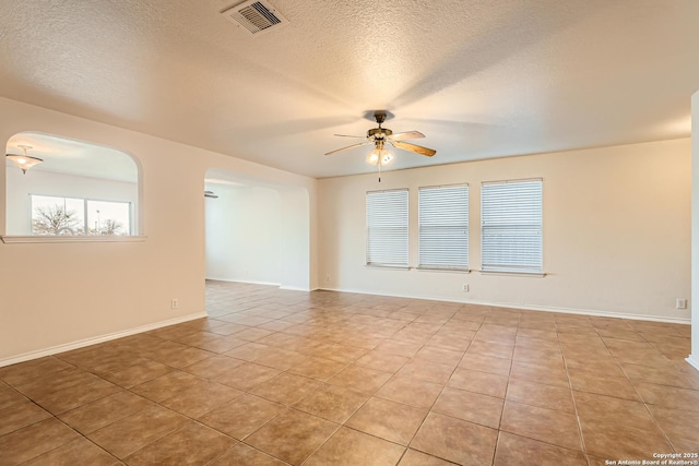 unfurnished room featuring ceiling fan, a textured ceiling, visible vents, and tile patterned floors