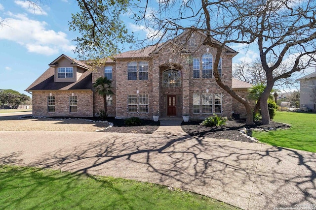 view of front of property with a front lawn and brick siding