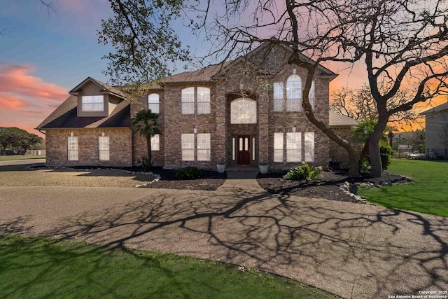 view of front of home with a front lawn and brick siding