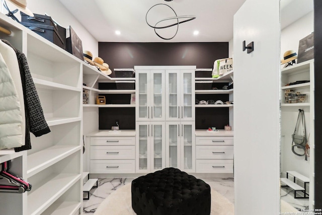 walk in closet with marble finish floor