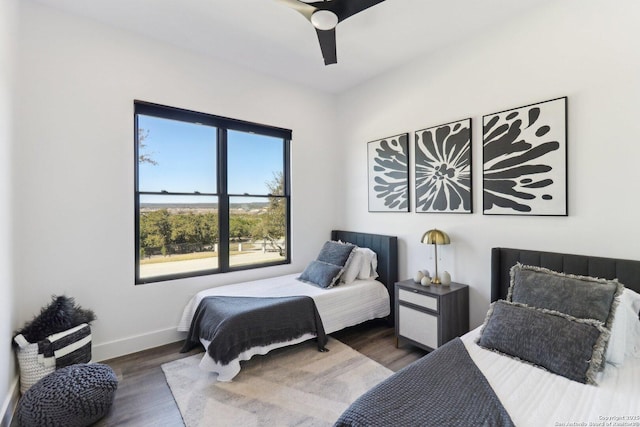 bedroom featuring ceiling fan, baseboards, and wood finished floors