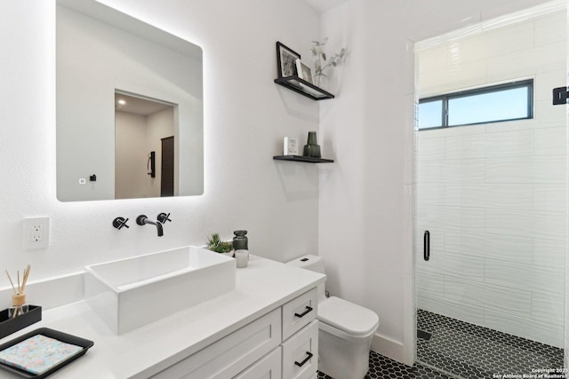 bathroom featuring toilet, a stall shower, and vanity