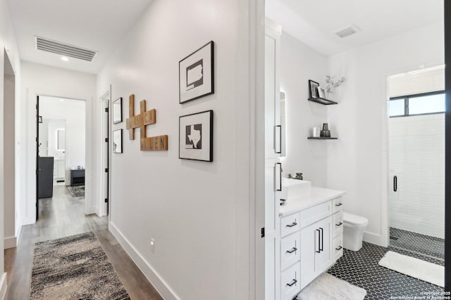 full bath with a stall shower, baseboards, visible vents, toilet, and vanity