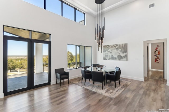 dining area featuring french doors, wood finished floors, visible vents, and baseboards