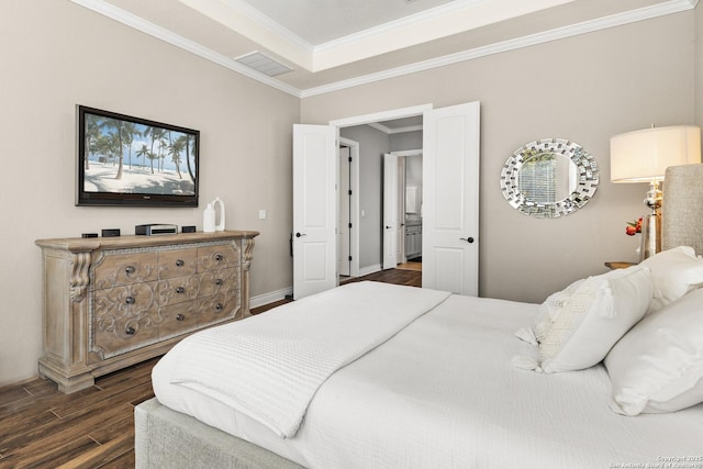 bedroom with baseboards, visible vents, ornamental molding, wood finished floors, and a tray ceiling