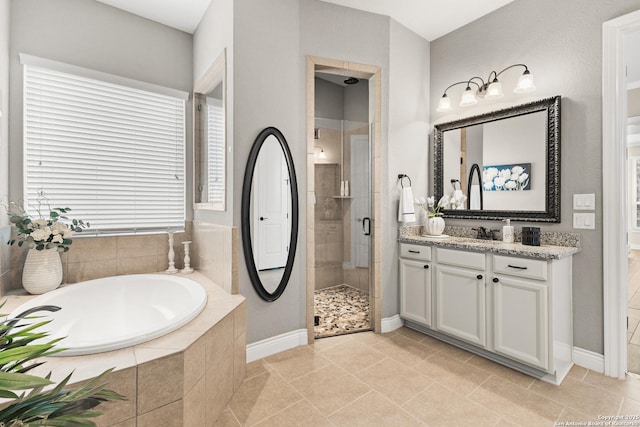 bathroom with baseboards, a garden tub, vanity, and a shower stall