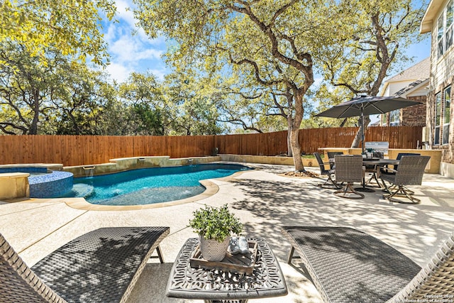 view of pool featuring a pool with connected hot tub, outdoor dining area, a fenced backyard, and a patio