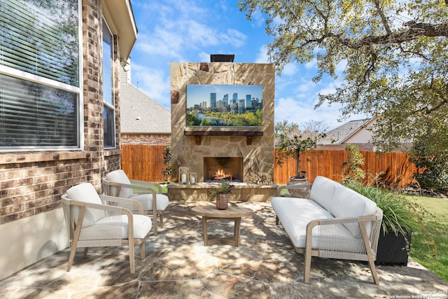 view of patio featuring an outdoor living space with a fireplace and fence