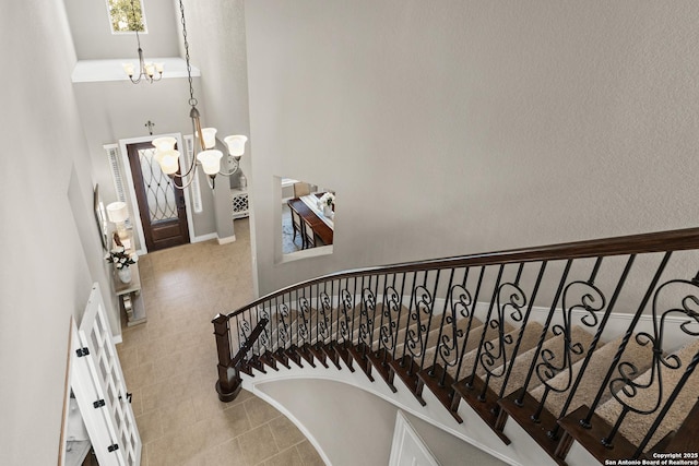 stairs with a towering ceiling and an inviting chandelier