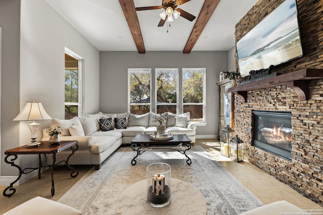 living room featuring beam ceiling, a fireplace, ceiling fan, tile patterned flooring, and baseboards