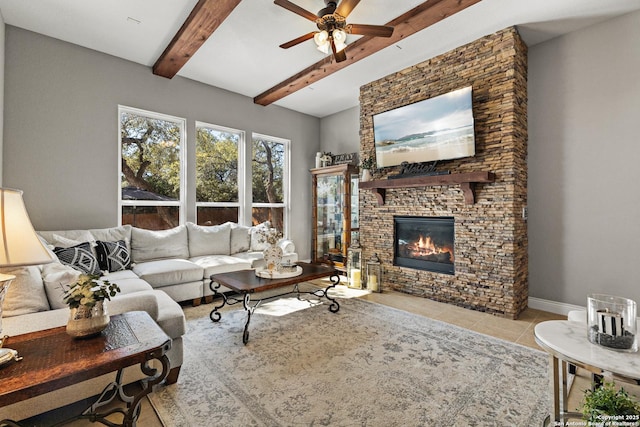 living room with ceiling fan, a large fireplace, baseboards, beam ceiling, and tile patterned floors