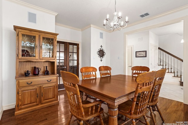 dining room with dark wood-style floors, visible vents, and ornamental molding