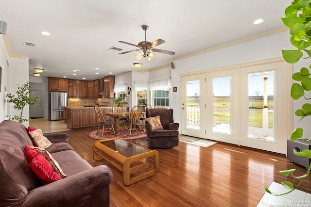 living room featuring recessed lighting, visible vents, crown molding, and light wood finished floors