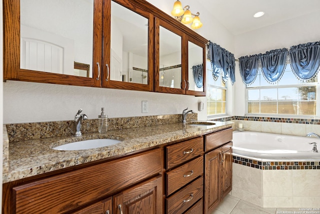 bathroom with tile patterned floors, a garden tub, a sink, and double vanity