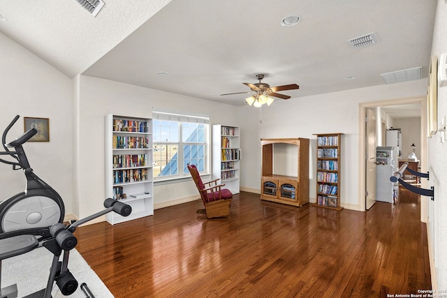 workout area with baseboards, visible vents, and wood finished floors