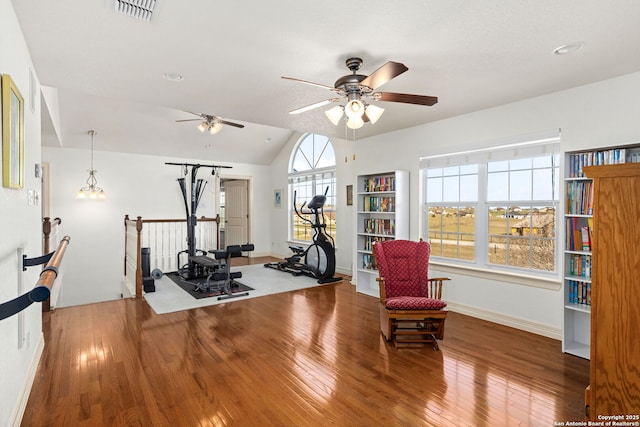 workout room with visible vents, a ceiling fan, vaulted ceiling, baseboards, and hardwood / wood-style flooring