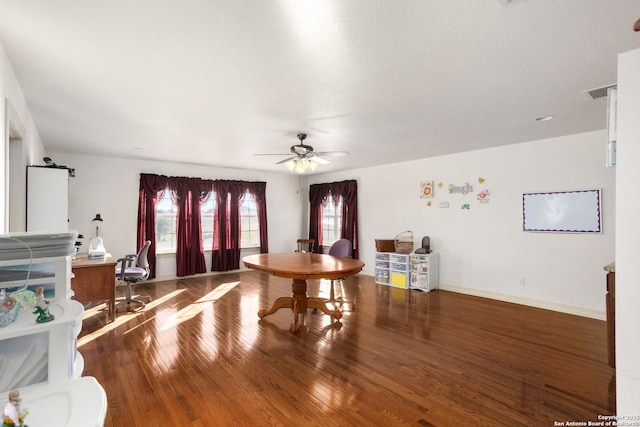 living area featuring ceiling fan, visible vents, baseboards, and wood finished floors