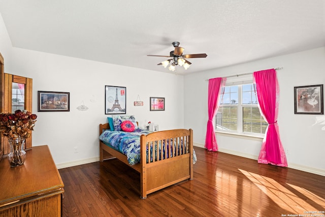 bedroom featuring hardwood / wood-style floors, a ceiling fan, and baseboards