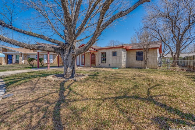 view of front of house with brick siding, a front lawn, and fence