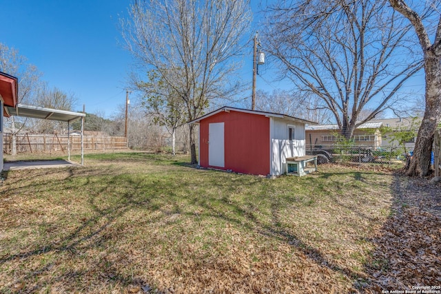 view of yard featuring an outbuilding, fence, and a storage shed