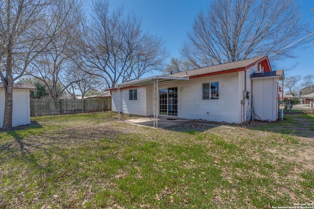 rear view of property featuring a patio area, fence, and a lawn