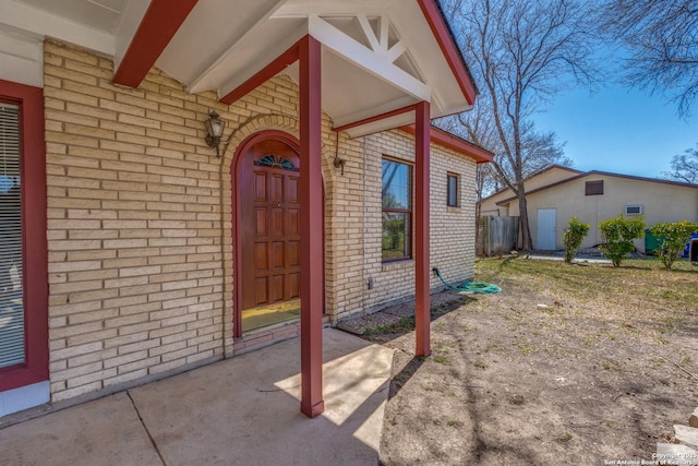 view of exterior entry featuring brick siding