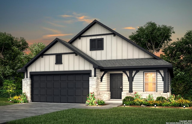 view of front facade with an attached garage, stone siding, board and batten siding, and roof with shingles