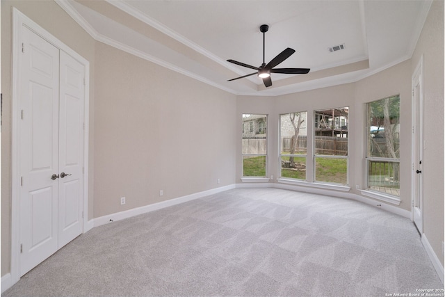 carpeted empty room with baseboards, visible vents, and ornamental molding