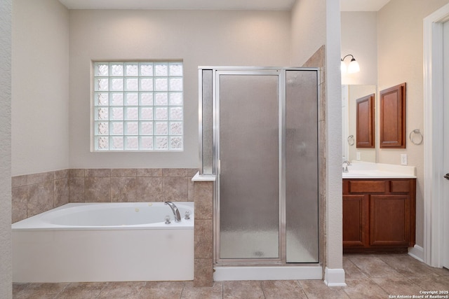 full bathroom featuring a stall shower, tile patterned flooring, a garden tub, and vanity