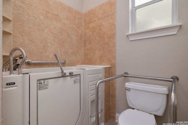 bathroom with toilet and a textured wall